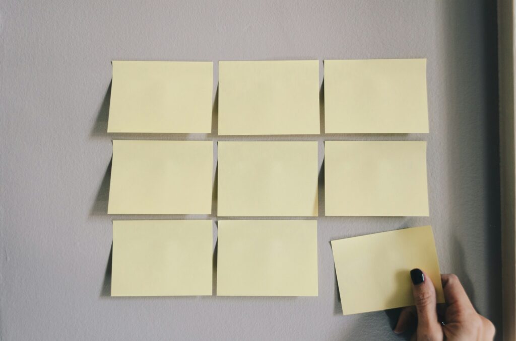 Six white sticky notes arranged on a wall, representing the structured, step-by-step approach that expert tax planning provides when preparing to sell a business. Strategic organization can significantly reduce tax burdens during an exit.
