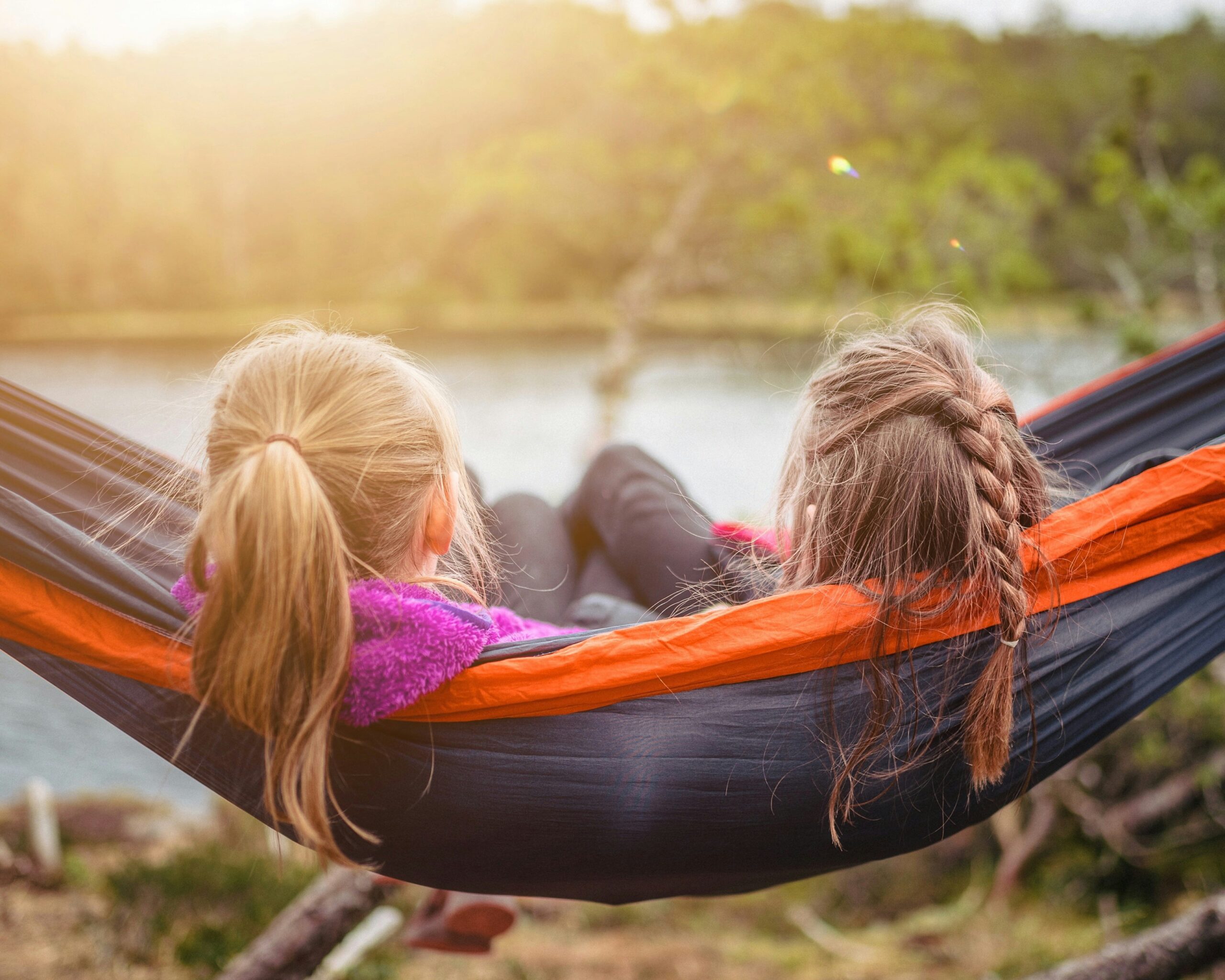 A mother and daughter relax together on a hammock in a sunny backyard, representing the everyday families who benefit from the Child Tax Credit. The image evokes the peace of financial relief and support for caregivers in 2025.