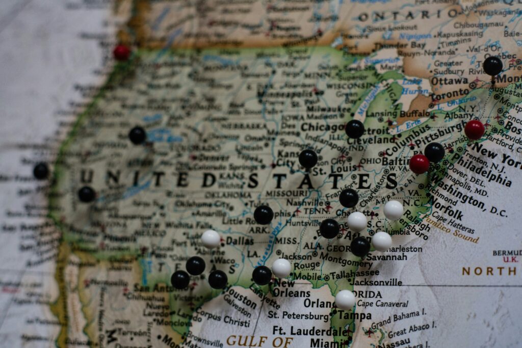 A detailed map of the United States pinned to a wall, symbolizing state-by-state differences in tax laws, business regulations, and strategic planning considerations for remote workers and business owners alike.