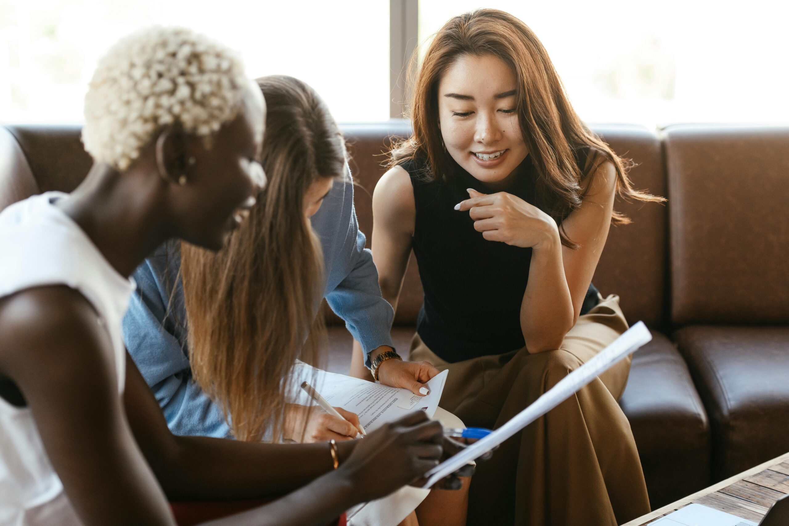 Three colleagues review documents in an office setting—illustrating how tax advisors are collaborating to interpret and communicate the wide-ranging effects of the One, Big, Beautiful Bill (OBBB).