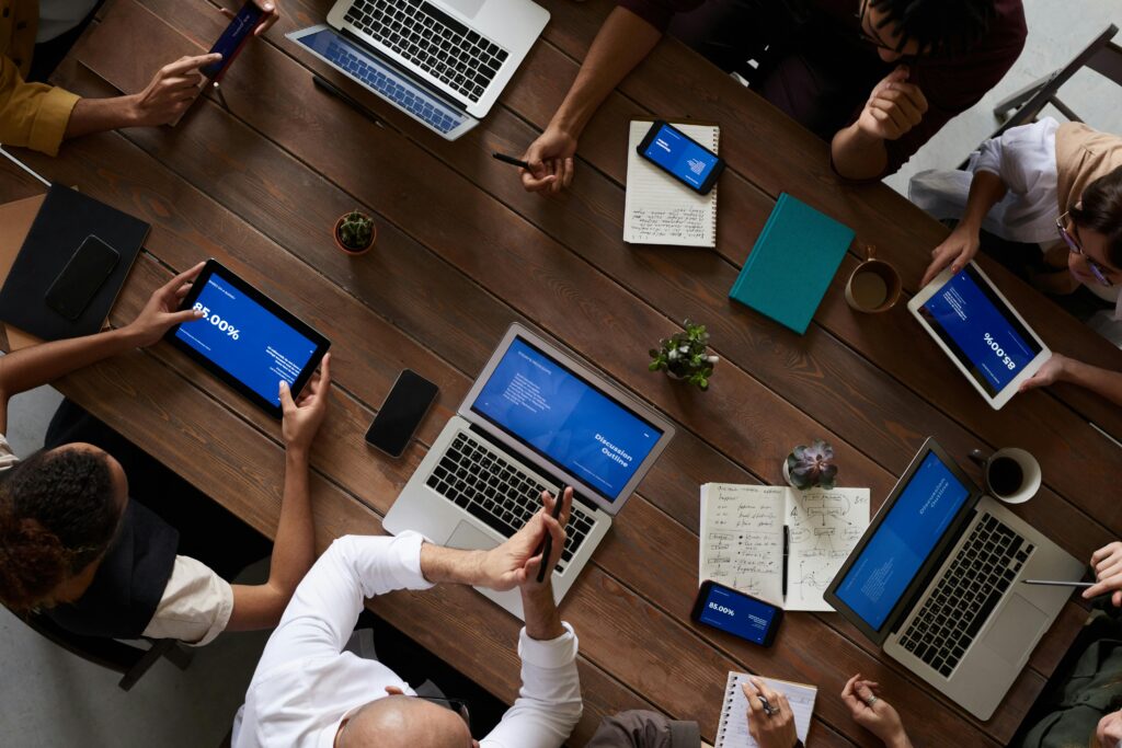 Image of people around a boardroom table on laptops.