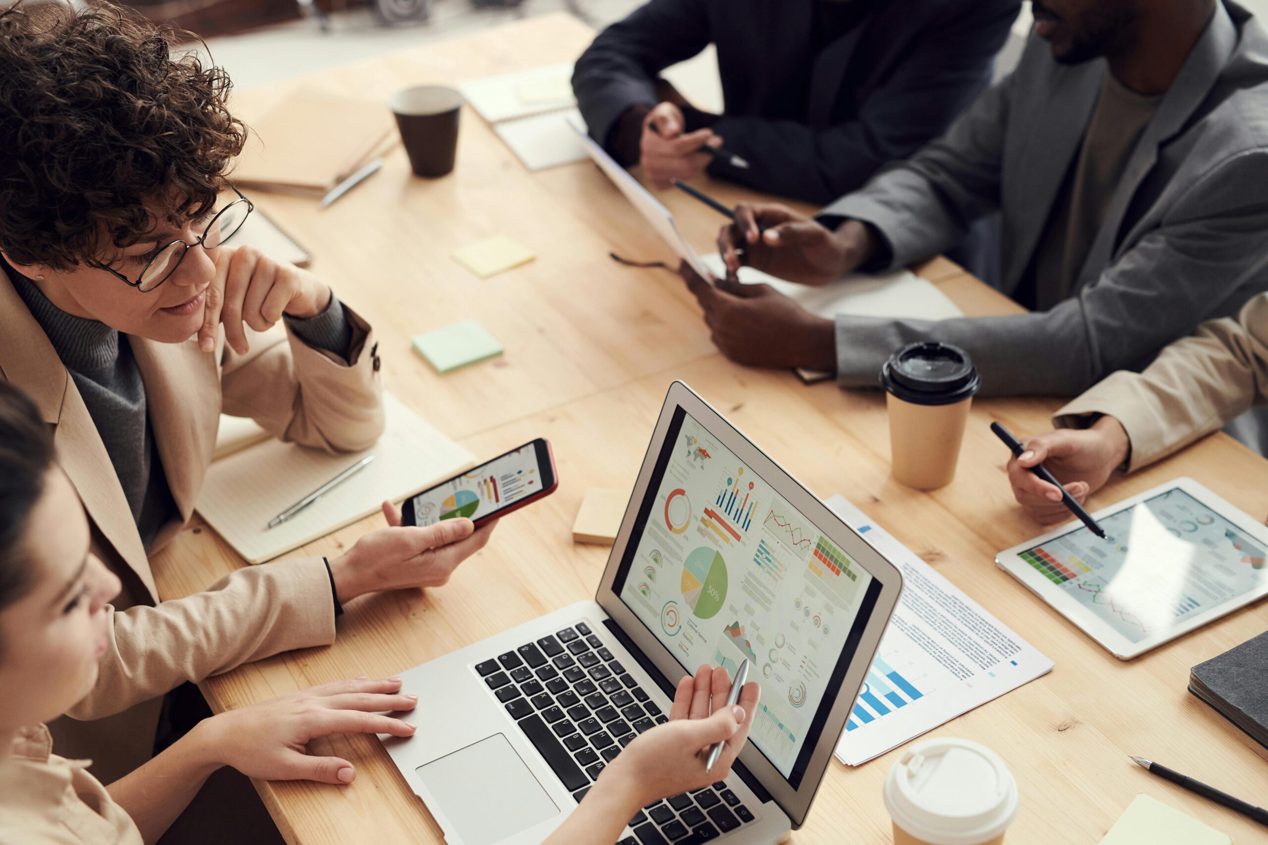 A team reviews financial reports at a table—illustrating the time and complexity involved in manual billing and collections