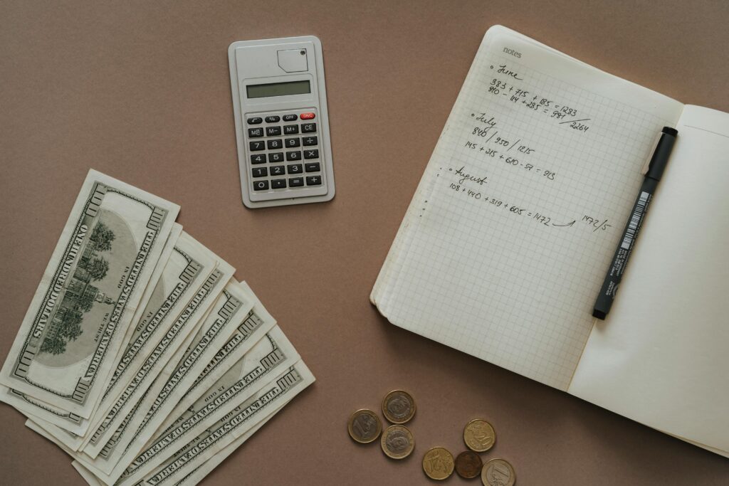An image of cash next to a notebook and calculator.