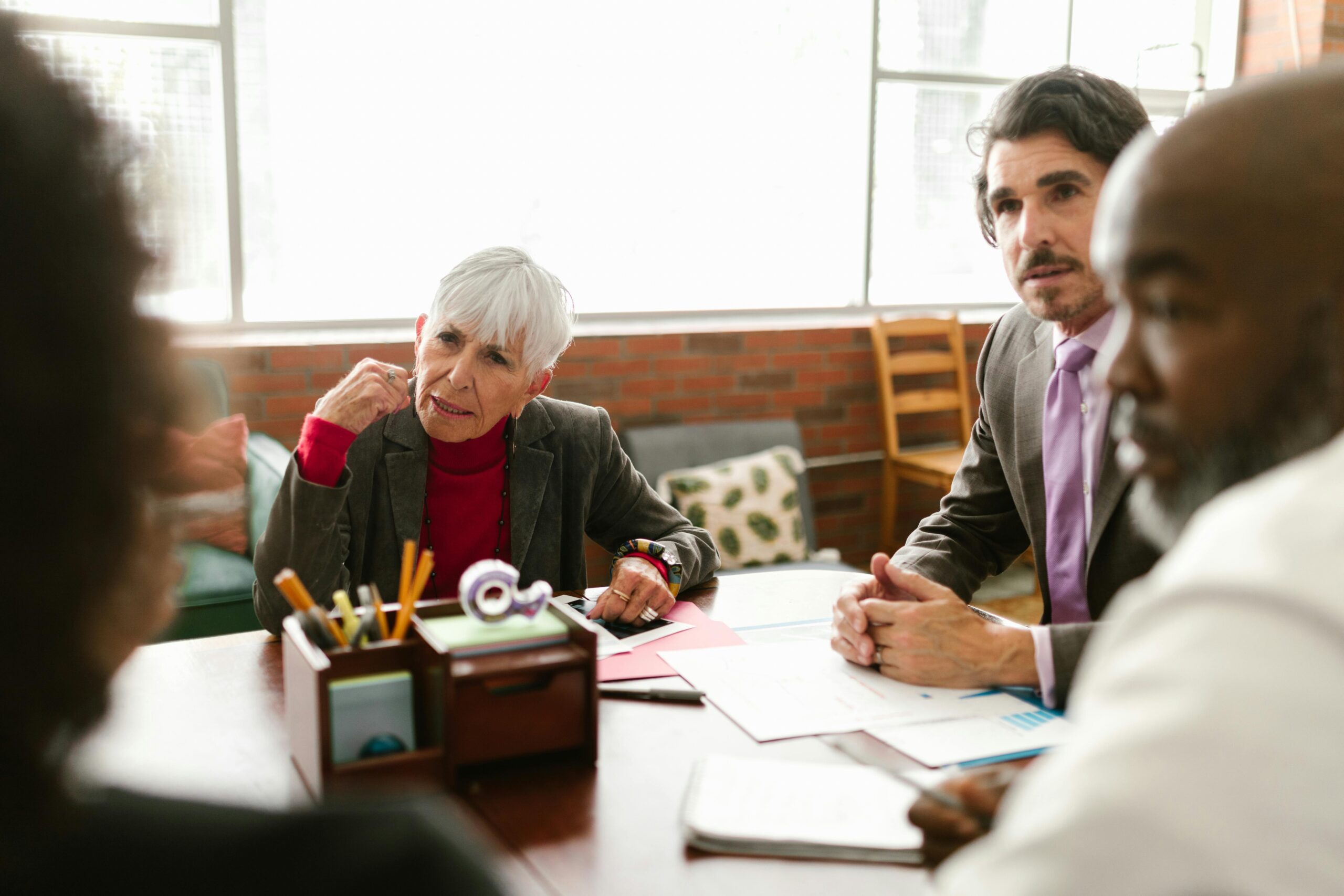A team gathers around a conference table to troubleshoot workflow issues—highlighting the collaborative effort required to identify hidden back-office bottlenecks in tax firms.