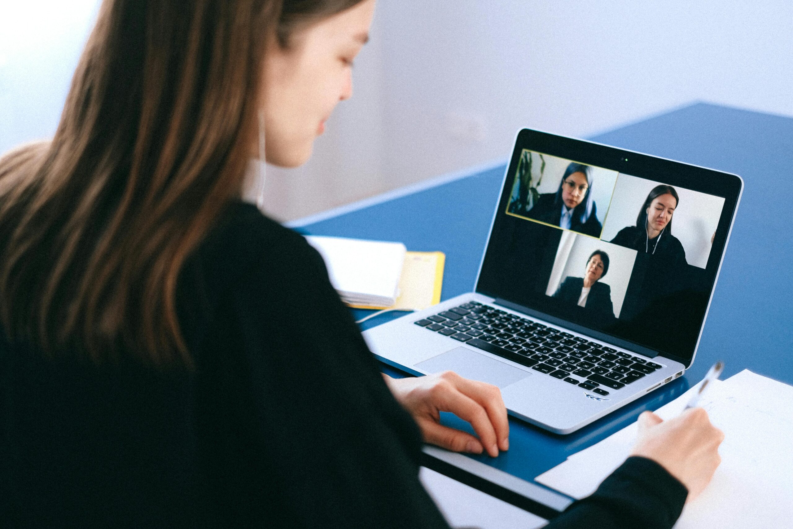 A team joins a virtual meeting on laptops—representing the shift to digital collaboration tools that power the modern tax firm’s back office.