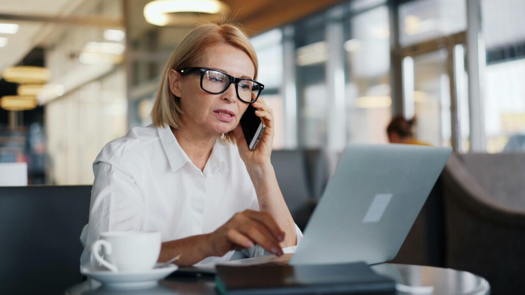 A tax advisor speaks on her phone while working from a digital workspace—illustrating how modern tools support seamless client communication and remote advisory services.
