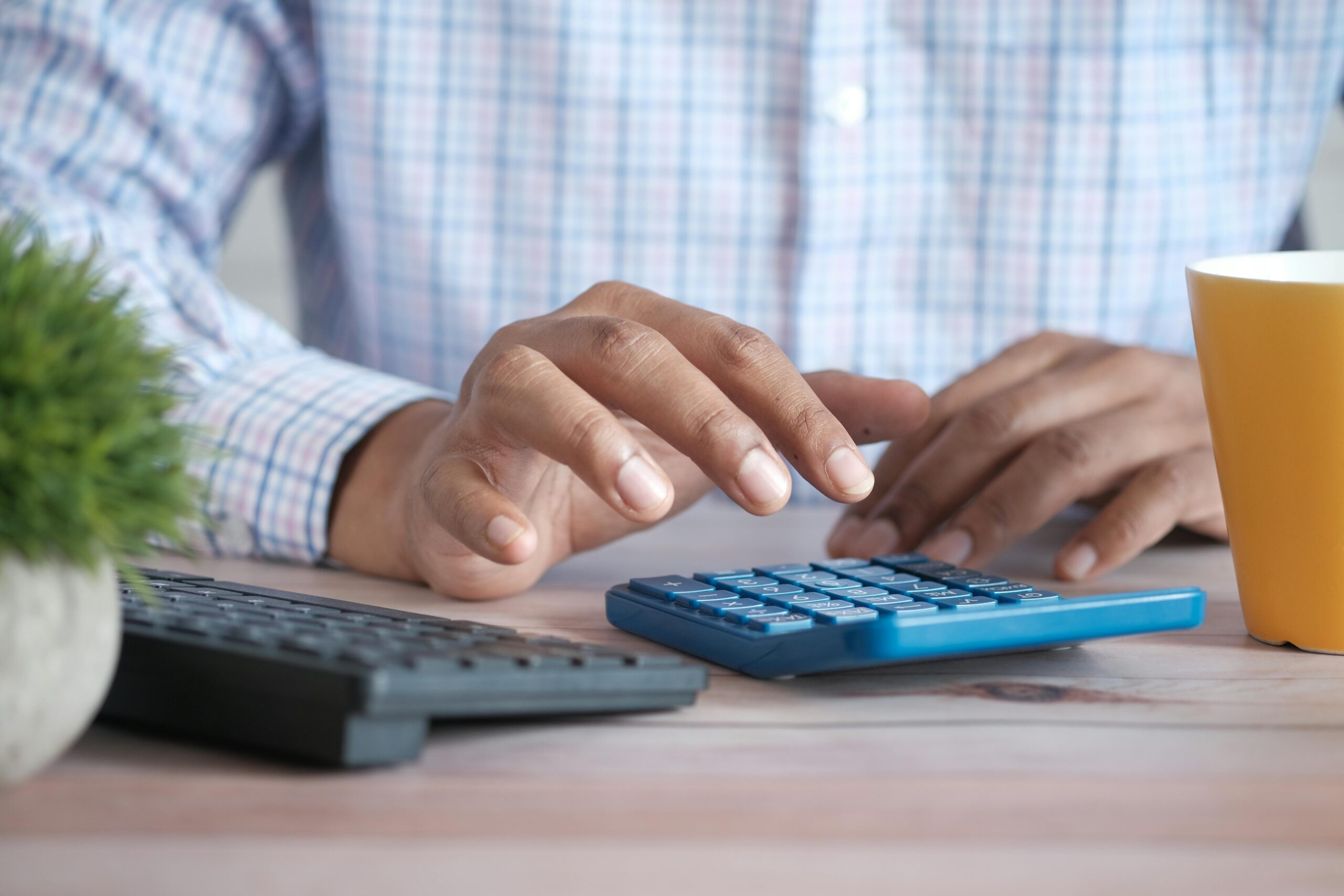 A person at a desk using a calculator.