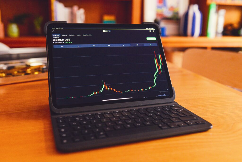 A modern laptop on a wooden desk in a clean, well-lit workspace—representing digital tools used for managing investments, researching capital gains strategies, and making informed financial decisions.