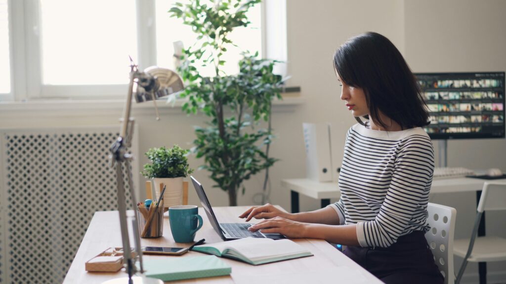 A woman sitting at a desk using a laptop computer, representing tax professionals adapting to new technologies and AI-driven changes in tax compliance and audits.