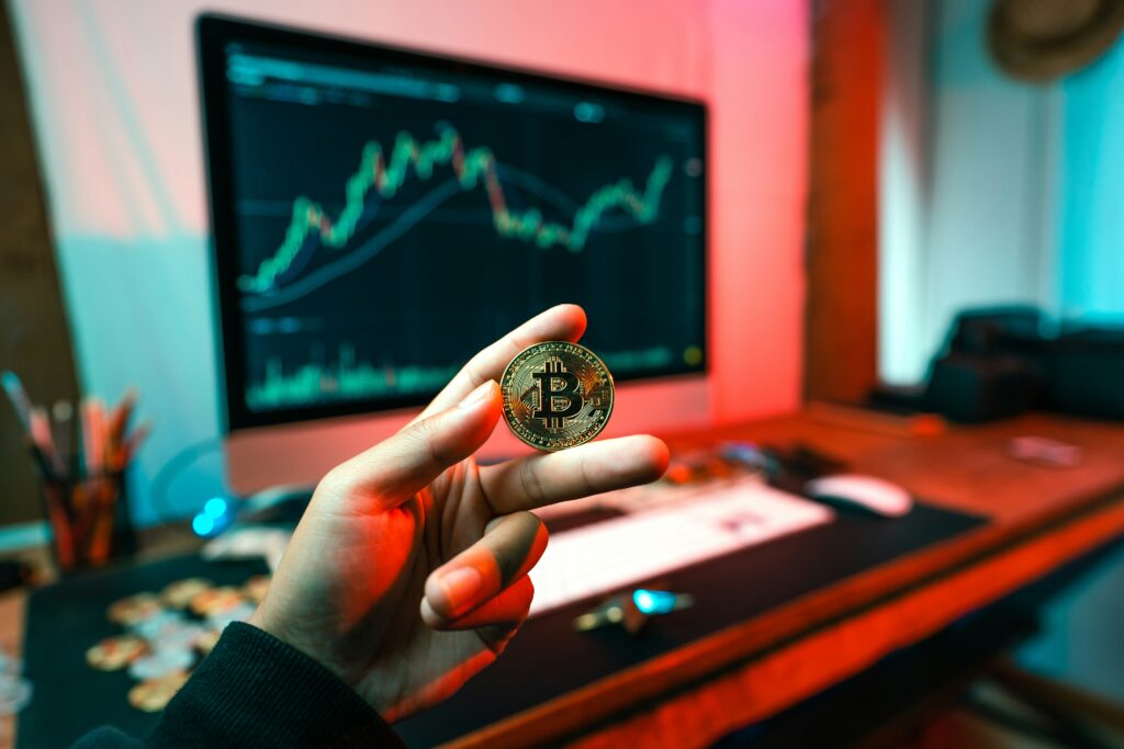 A person holding bitcoin while reviewing cryptocurrency dashboards—representing the growing need for individuals to track, report, and manage digital asset gains during tax season.