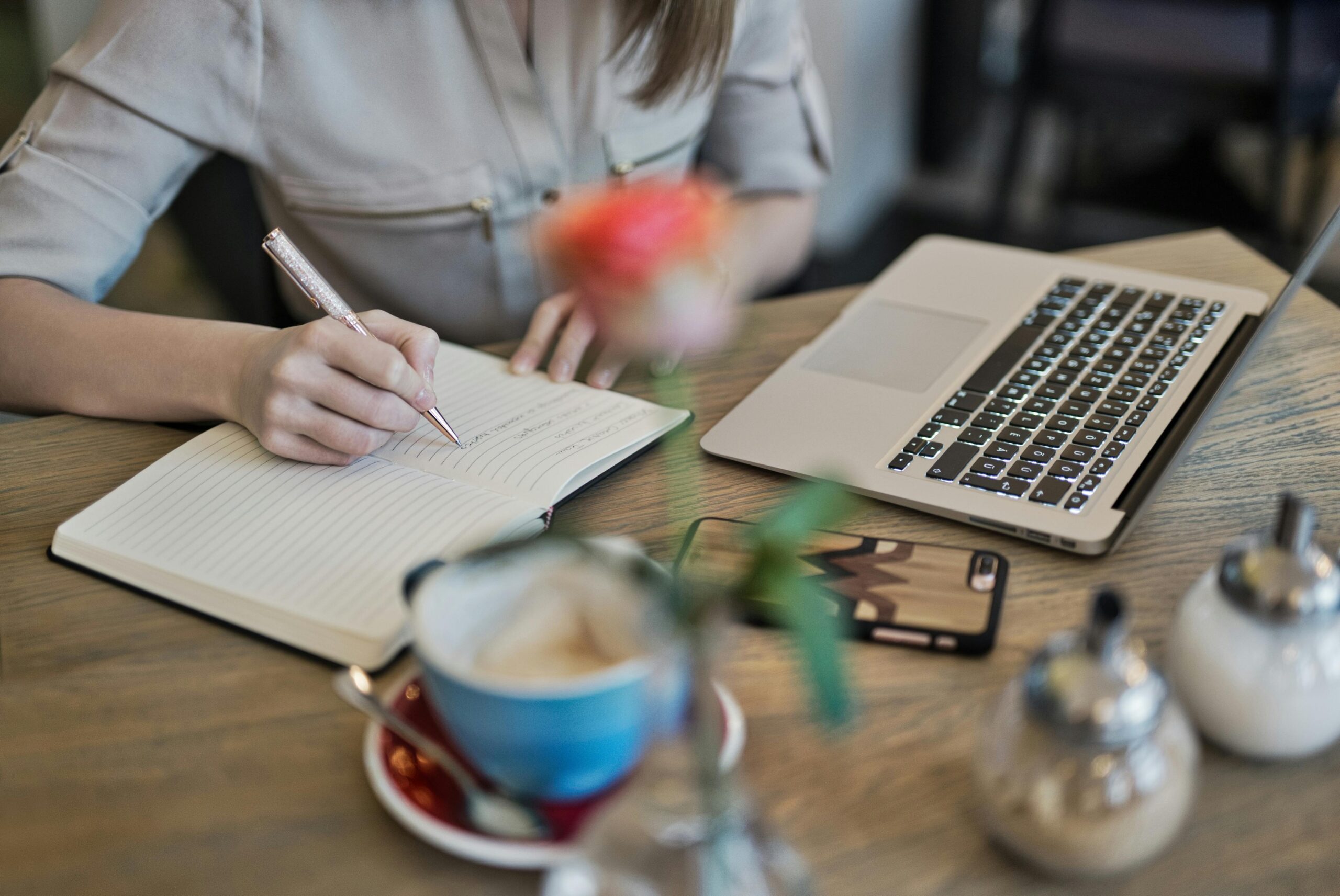 A freelancer at home working on a laptop and taking notes—representing the proactive planning needed to calculate and manage federal quarterly tax payments.
