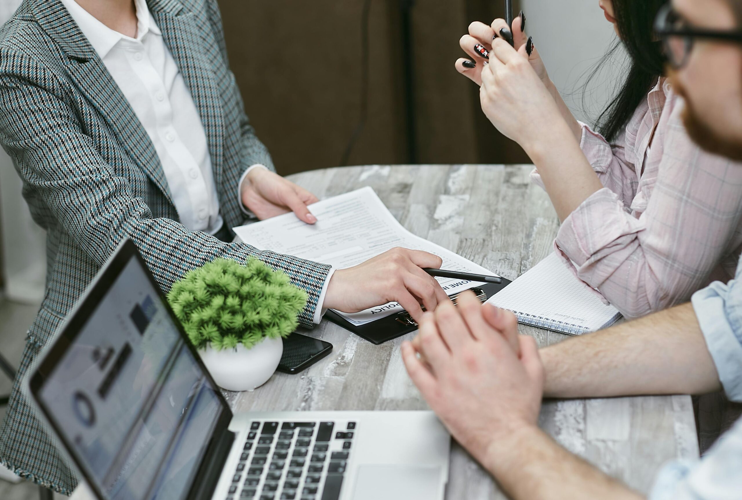 Image of three people sitting around a table discussing mortgages.