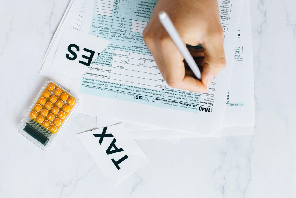 A person filling out tax forms at a desk—representing the importance of timing and structuring property tax payments to improve real estate cash flow and avoid large lump-sum liabilities.