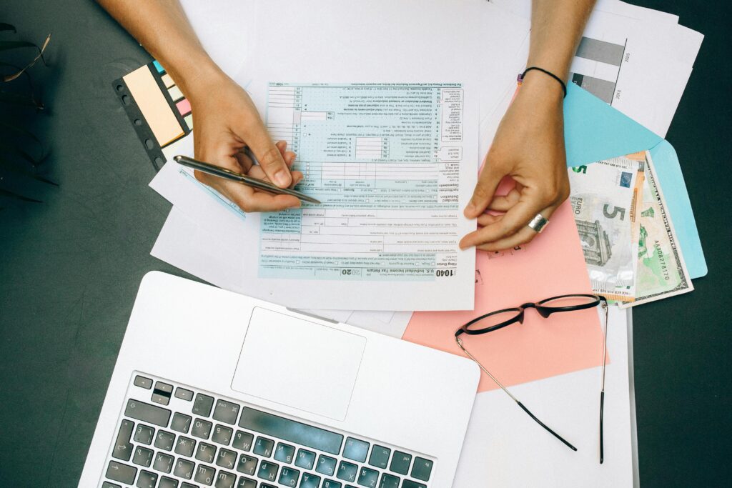 An individual reviewing and filling out financial documents—depicting the potential consequences of missed or incorrect quarterly tax filings and the need for careful documentation.