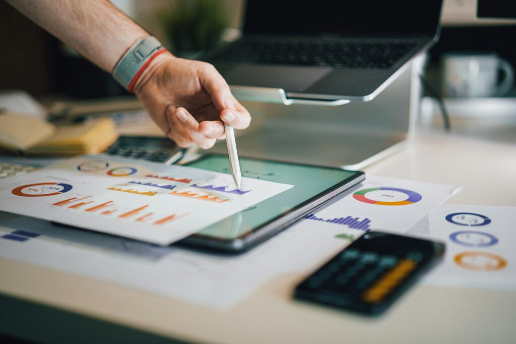 A person studying business performance charts on a tablet—symbolizing how digital tools like Harness help visualize contribution margins and guide better financial decisions.