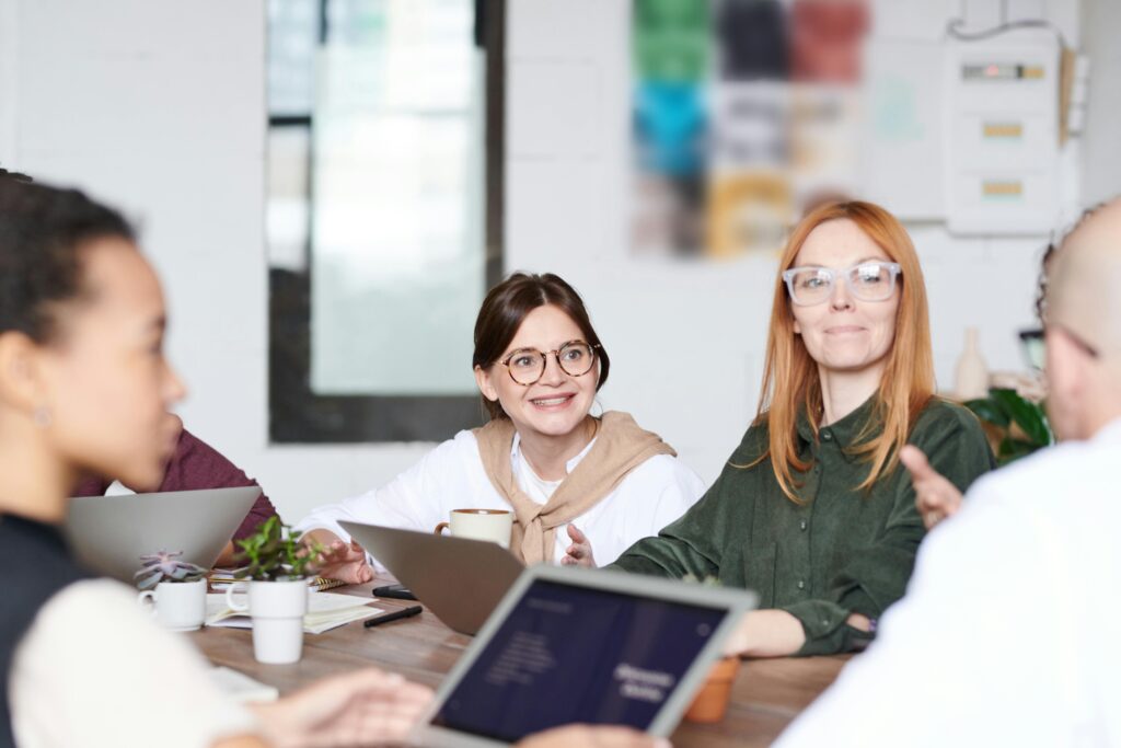A group of professionals collaborating around a table—illustrating the value of peer expertise and professional networks like Harness in resolving intricate tax challenges tied to shareholder agreements.