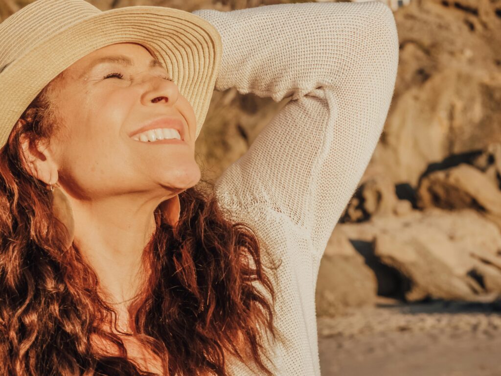 A woman in a white sun hat gazes out over a scenic view, evoking the peace of a well-planned retirement—ideal for illustrating the lifestyle benefits of minimizing RMD taxes for high net worth individuals.