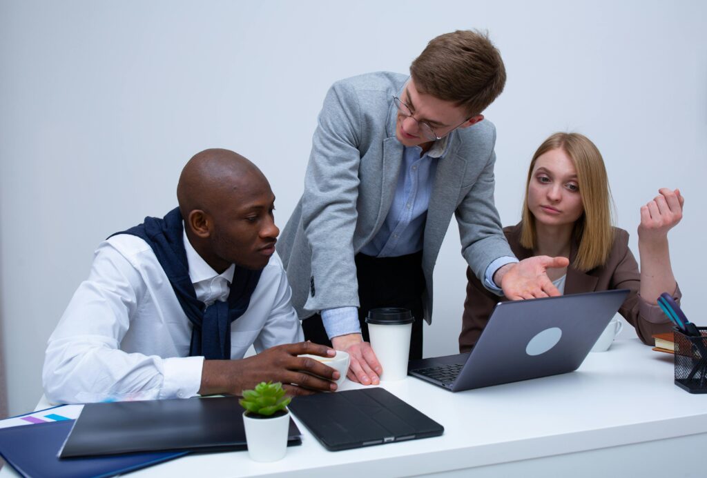 Two professionals in business attire discuss financial strategies in a modern office setting—symbolizing the importance of early planning and advisory when managing Net Investment Income Tax (NIIT) during major liquidity events.