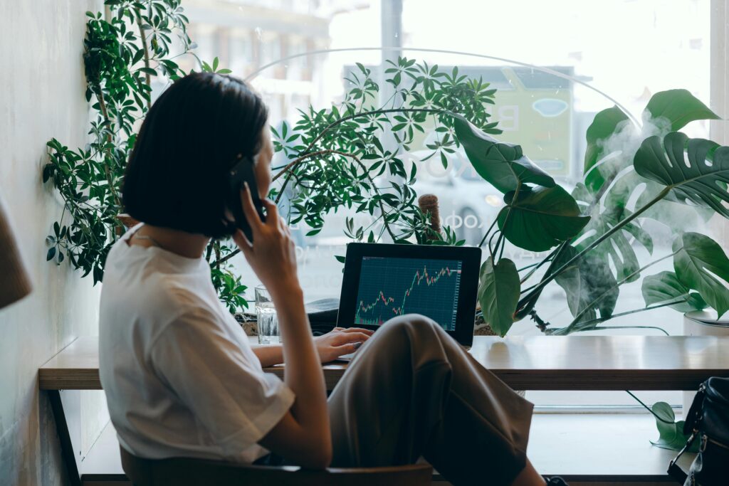 A businesswoman speaks on the phone while reviewing documents—representing shareholders or founders navigating tax implications of IPOs, M&A, or other high-gain liquidity events subject to the 3.8% NIIT surtax.