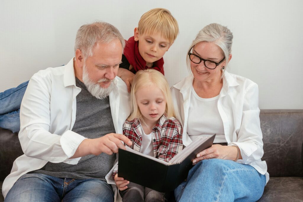 Image of a family sitting around their children reading a book.