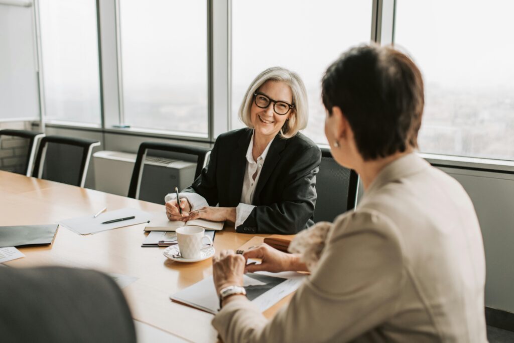 A professional woman in a modern office setting attentively listens during a discussion—symbolizing the importance of expert tax guidance when navigating inheritance strategies like the Step-Up in Basis.