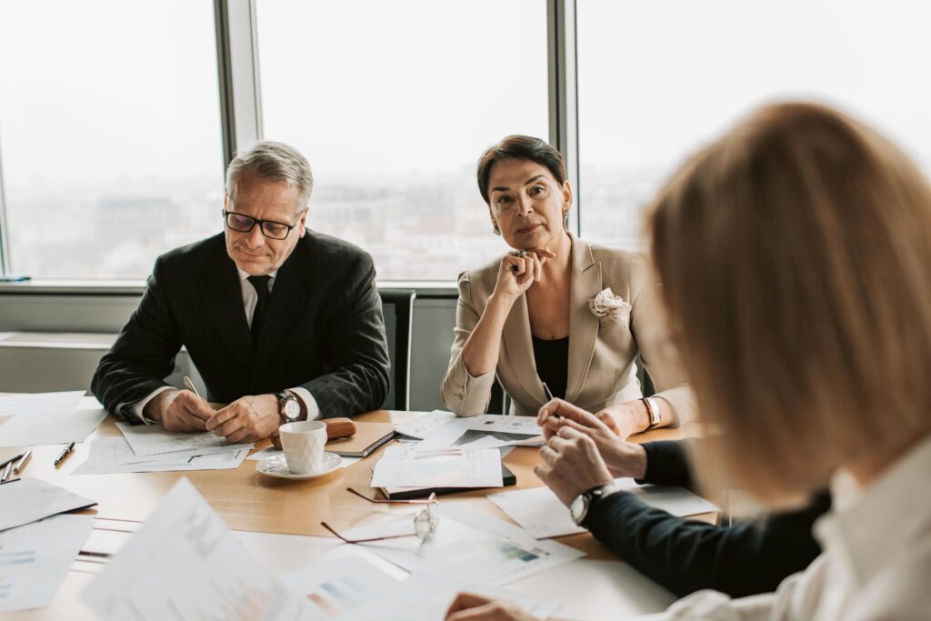 A group of professionals engaged in a business meeting in a bright, modern office—illustrating the role of collaborative platforms like Harness in helping tax advisors manage complex inheritance and estate tax planning.