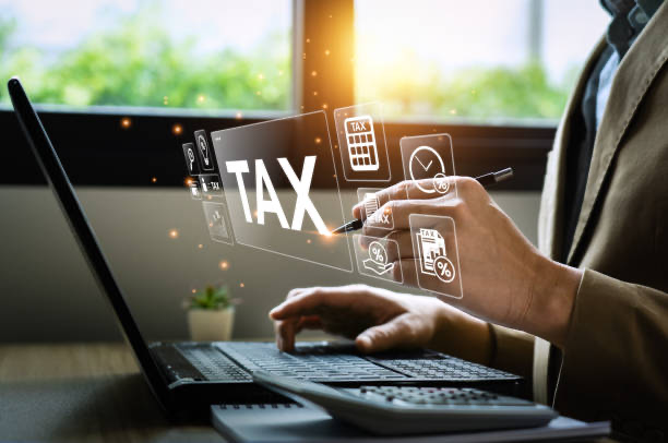 Close-up of accountant using laptop and calculator with digital tax icons.
