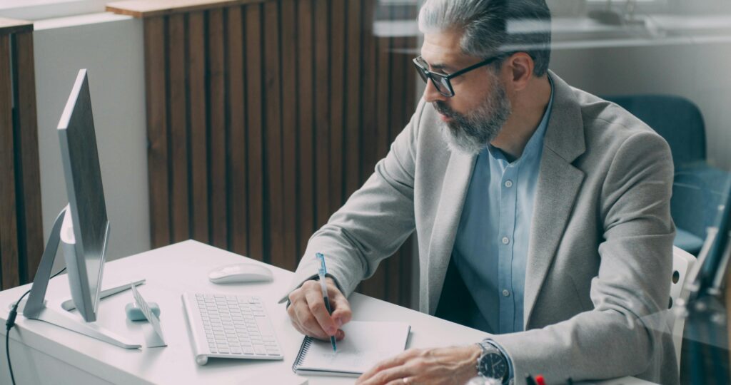 A professional man working at an office desk, symbolizing the importance of understanding the SALT deduction limit in 2025.