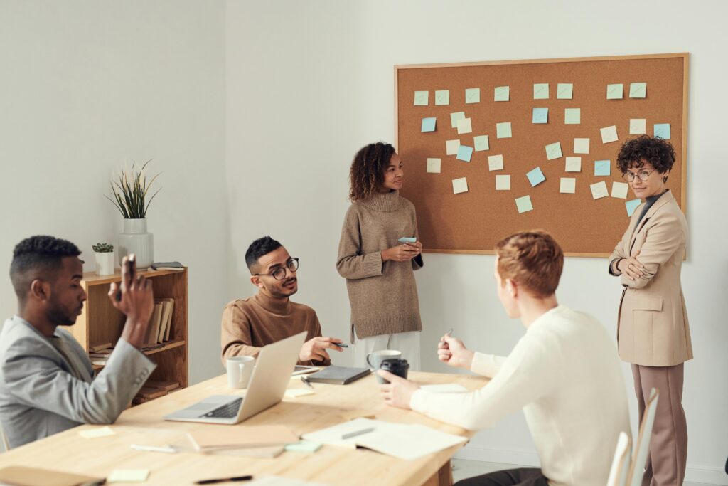 Two small business owners reviewing a 2025 tax deductions checklist on a corkboard — concept of staying organized for small business tax savings.